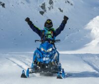 Man Riding Blue SnowMobile