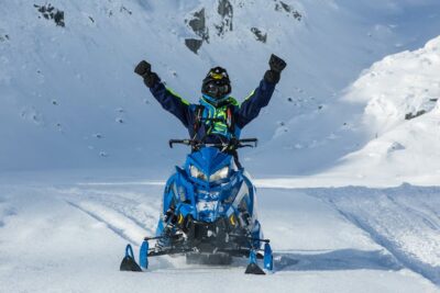 Man Riding Blue SnowMobile