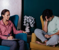 A teenage girl is sitting near a female psychologist