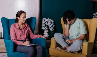 A teenage girl is sitting near a female psychologist